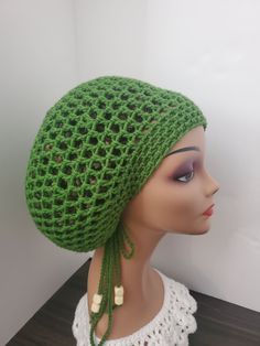 a mannequin head wearing a green crochet hat