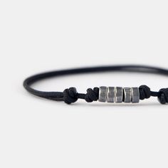 This men's beaded bracelet effortlessly combines a minimalist design with a touch of sophistication and masculinity, creating a captivating and unique piece. The combination of oxidizing surface and texture of handmade silver beads on the black cord catches the eye and adds a touch of personality to your style. With its lightweight and durable construction, this cord bracelet is designed for everyday wear. The adjustable cord ensures a comfortable and secure fit, making this minimalist bracelet a perfect accessory for your everyday adventures. D E T A I L S * 1.5 mm strong black nylon cord for comfortable everyday wear. * Oxidized sterling silver beads, approximately 5 mm. * Adjustable length with sliding knots. * Available in various sizes for a customized fit. * Designed in Barcelona. Al Everyday Silver Minimalist Wristband, Minimalist Silver Wristband For Everyday, Masculine Everyday Adjustable Bracelets, Minimalist Sliding Knot Bracelets, Modern Adjustable Beaded Bracelets For Everyday, Modern Adjustable Beaded Bracelets For Everyday Wear, Modern Adjustable Wristband For Everyday, Silver Minimalist Wristband, Modern Adjustable Wristband For Everyday Wear