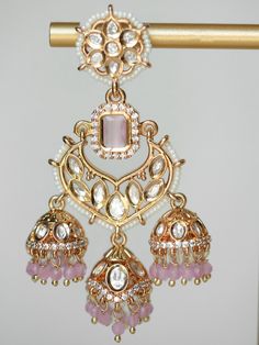 Discover one of BAALI's most-loved unique South Asian jewelry pieces: the Kanwal Jhumka. This modern statement earring is a fusion of traditional jhumka and chandbali style earrings featuring a triple jhumka design, elegant flower motif, and striking colored center stone with matching gemstone beads. These one-of-a-kind kundan jhumka earrings are luxurious lightweight 21K gold-plated earrings. The contemporary design of this artisanal earring is meticulously adorned with dazzling kundan stones that bring BAALI's signature sparkle to every room. Materials: 21K gold plating on brass, kundan stones, gemstone beads, pearls Dimensions (L x W): 2.9 x 1.8 inches Weight: 21g (per jhumka) Luxury Formal Chandbalis, Luxury Drop Chandbalis For Celebration, Dual-tone Chandbali Fusion Jhumkas, Traditional Pink Chandbali Earrings, Pink Fusion Chandbali Jhumkas, Traditional Pink Cutdana Jhumkas, Traditional Pink Dangle Jhumkas, South Asian Jewelry, Jhumka Design