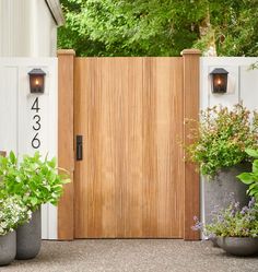 a wooden door with two planters on either side