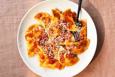 a white plate topped with pasta covered in sauce