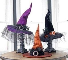 three halloween decorations on a table in front of a window