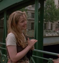 two people standing on a bridge and one is holding her hand out to the other