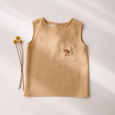 Kids linen relaxed fit tank top with front pocket and button closure at the back. This item is MADE TO ORDER. Please allow up to 3-7 business days production time before shipping.  Material: 100% medium weight linen, Oeko-Tex 100 certified. Sizing Guidelines (this item runs true to the size): 12-18 months (86cm / 34in. height) 18-24 months (92 cm / 36.25 in. height)  2-3 YRS (98 cm / 38.5 in. height) 3-4 YRS (104cm / 41in. height) 4-5 YRS (110cm / 43in. height) 5-6 YRS (116cm / 45.5in. height) 6-7 YRS (124cm / 49 in. height) 7-8 YRS (130cm / 514 in. height) Recommended Care Instructions: Machine wash cold water, delicate cycle, dry gentle. Spring Cotton Vest With Side Pockets, Cotton Vest With Side Pockets For Spring, Cotton Tank Top With Pockets For Summer, Spring Cotton Tank Top With Pockets, Summer Cotton Tank Top With Pockets, Beige Sleeveless Tops With Pockets, Beige Cotton Tops With Side Pockets, Cotton Tops With Side Pockets For Summer, Summer Everyday Tops With Side Pockets