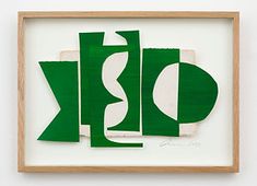 an abstract piece of paper with the letter k in green and white, hanging on a wall