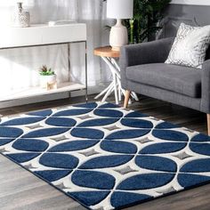 a blue and white rug in a living room with a couch, chair and table