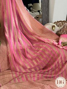 Indulge in luxury and elegance with our Banarasi Khaddi georgette saree in beautiful pink stripes. Handcrafted with intricate details, this saree exudes exclusivity and sophistication. Perfect for any occasion, this saree elevates your style and adds a touch of glamour to your wardrobe. Saree comes with a blouse piece. Fall and pico done. Fully stitched blouse shown in pictures is optional and can be purchased seperately from our blouses and croptops section. For saree video please connect with us on whatsapp @469-937-0606 Ready to be shipped in USA from San Diego, California. All pictures are original pictures. Colors may slightly vary due to pic resolution. Elegant Pink Chanderi Pre-draped Saree, Elegant Pink Pre-draped Saree With Zari Weaving, Festive Georgette Pre-draped Saree With Border, Traditional Pre-draped Georgette Saree With Border, Elegant Pink Georgette Blouse Piece, Elegant Pink Blouse Piece With Zari Weaving, Elegant Pink Pre-draped Saree For Festivals, Pink Georgette Pre-draped Saree With Sheer Dupatta, Elegant Pink Chanderi Saree