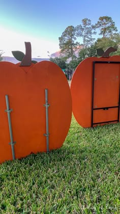 two large orange pumpkins sitting in the grass