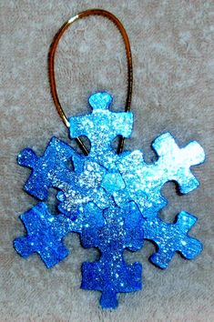 a blue snowflake ornament hanging from a leather cord on a carpet