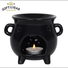 a black pot with a lit candle in it and the words gift of the year written below