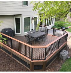 a deck with table and chairs next to a house