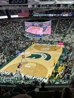 an indoor basketball court with fans watching it