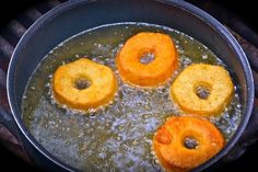 three donuts frying in oil on top of a stove