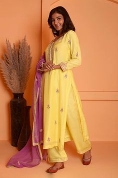 Yellow kurta featuring dori embroidered floral and paisley motifs highlighted with gota lace embellishments. Comes with palazzo and dupatta.
Components: 3
Pattern: Embroidered
Type Of Work: Floral, Gota, Dori
Neckline: Round
Sleeve Type: Three quarter
Fabric: Cotton Silk
Color: Yellow
Other Details: 
Length:
Kurta: 47 Inches
Palazzo: 38 Inches
Dupatta: 2.5 Mtr 
Occasion: Sangeet,Mehendi and Haldi - Aza Fashions Lace Embellishments, Yellow Kurta, Kurta Palazzo Set, Paisley Motifs, Palazzo Set, Embroidered Silk, Set For Women, Cotton Silk, Aza Fashion