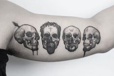 a man's arm with three skulls on it