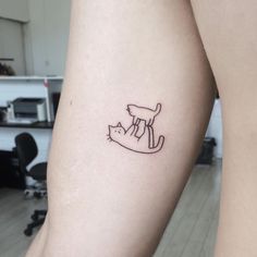 a cat tattoo on the left arm is shown in black ink, and it appears to be an outline