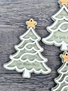 three christmas tree shaped cookie cutters sitting on top of a wooden table