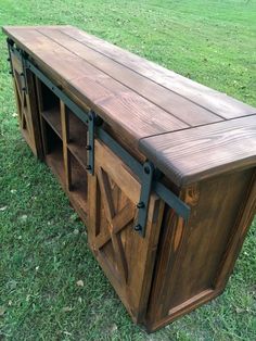 a large wooden cabinet sitting on top of a lush green field