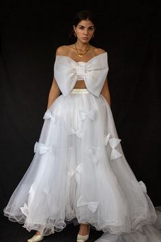 a woman in a white dress standing on a black background