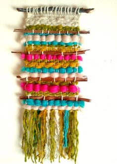 a wall hanging made out of different colored yarns