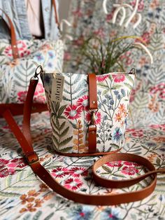 a small purse sitting on top of a table next to a flowered cloth bag