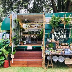 a food truck with plants on the outside and steps leading up to it's entrance