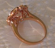 A beautiful and substantial engagement ring featuring a round peachy-pink untreated morganite center stone set in 14K rose gold elegant filigree ring. The center stone is a peachy-pink morganite, measuring about 9mm diameter (approximately 2.5 carats). It is cut in a Portuguese cut and very lively. The delicate peachy pink color of this morganite complements the rose gold very nicely. The morganite is set in an antique-inspired 14K rose gold filigree ring, featuring 0.16 carats of GH VS2 diamond Luxury Rose Gold Topaz Ring For Wedding, Formal Rose Gold Topaz Ring With Halo Setting, Rose Gold Flower Ring With Rose Cut Diamonds, Rose Gold Flower Ring With Prong Setting, Morganite Sapphire Ring With Halo Setting, Formal Rose Gold Flower Ring, Rose Gold Morganite Topaz Ring, Sapphire Ring With Halo Setting, Rose Gold Flower Ring With Center Stone