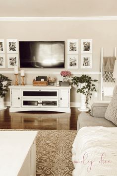 a living room with pictures on the wall and a flat screen tv mounted to the wall