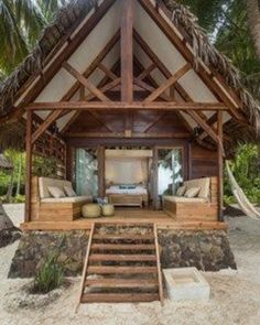 a beach house with steps leading up to the bedroom and sitting area in front of it