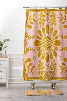 a pink and yellow shower curtain with an ornate flower design on the front in a bathroom