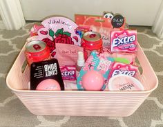 a pink basket filled with lots of different types of items on top of a carpet