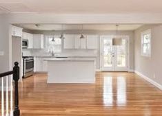 an empty kitchen and living room with hardwood floors