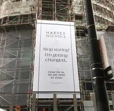 a large sign on the side of a building that is under construction with scaffolding around it