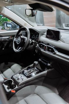 the interior of a car with grey leather seats and dash board, steering wheel and center console