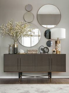 an elegant console with mirrors and vases on it