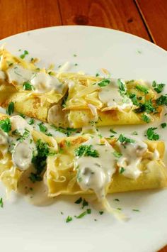 crepes with cheese and parsley on a white plate