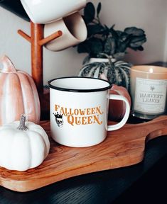 there is a coffee cup that says take it easy on the table next to some pumpkins