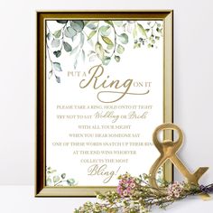 an elegant wedding card with gold foil and greenery is displayed next to a pair of scissors