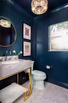 a bathroom with blue walls and gold accents, including a white toilet in the center