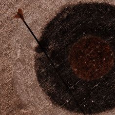 a brown object on the ground with a long stick sticking out of it's center