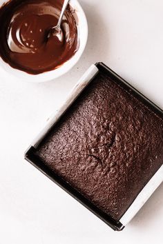 a bowl of chocolate cake next to a square pan