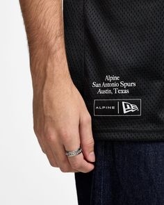 a close up of a man's hand wearing a new york yankees jersey with the san antonio spurs logo on it