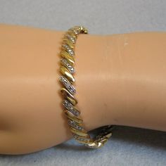 This fabulous vintage gold over sterling bracelet looks just like the real thing.  The detail is amazing .  The design makes it appear that each link has a row of small diamonds.  In Truth, only the center link has one small real diamond.  The bracelet measures just 1/4th inches high and 7 1/4 inches long.  There is an insert type clasp with a safety fold over loop.  The bracelet is in excellent condition and is marked, 925 for sterling.  We will send this to you in a lovely gift box for easy gi Gold Diamond Bracelet With Metal Accents, Gold Diamond Bracelet With Diamond Accents, Anniversary Chain Bracelet With Diamond Accents, Vintage Gold Diamond Bracelet With Accents, Vintage Gold Diamond Bracelet With Diamond Accents, Vintage Gold Tennis Bracelet For Anniversary, Loose Bracelet, Bangle Design, Gold Bracelet Simple