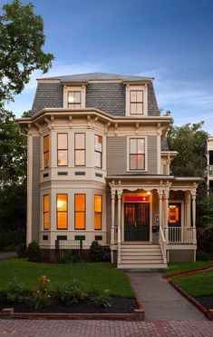 a large house with lots of windows on it's front porch and steps leading up to the second floor