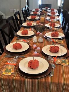 the table is set for thanksgiving dinner with plates and napkins on top of it