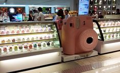 a pink camera sitting on top of a counter in a store