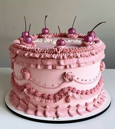 a large pink cake with cherries on top