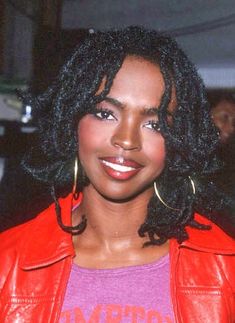 a close up of a person wearing a red jacket and large gold hoop earring