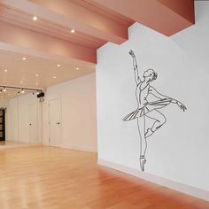 a black and white drawing of a ballerina on a wall in an empty room