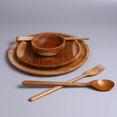 two wooden spoons and one bowl on a plate